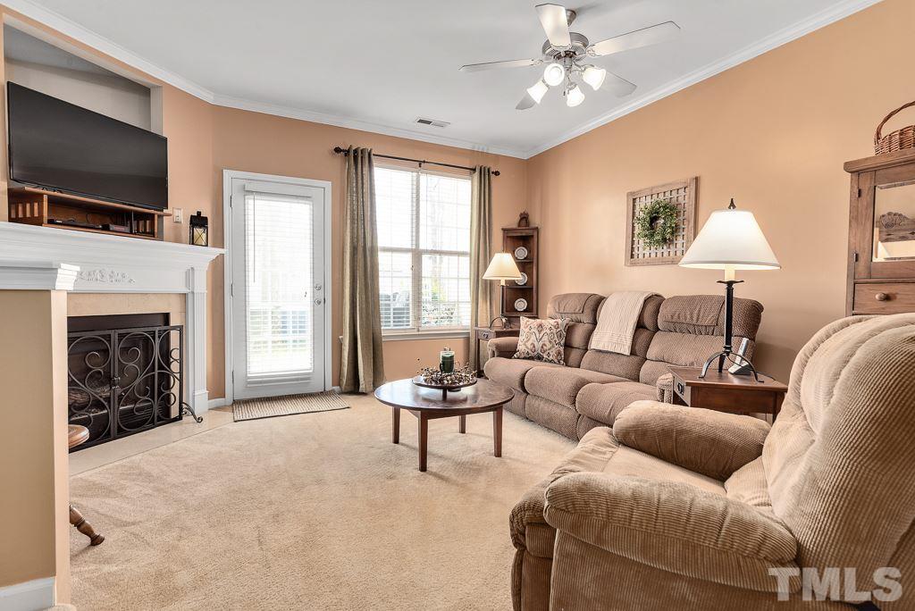 8348 City Loft Court Raleigh, NC 27613 - Photo 12 of 24 a living room with furniture a fireplace and a flat screen tv