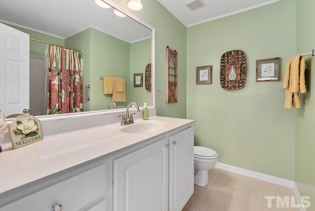 8348 City Loft Court Raleigh, NC 27613 - Photo 20 of 24 a bathroom with a sink a toilet and a mirror