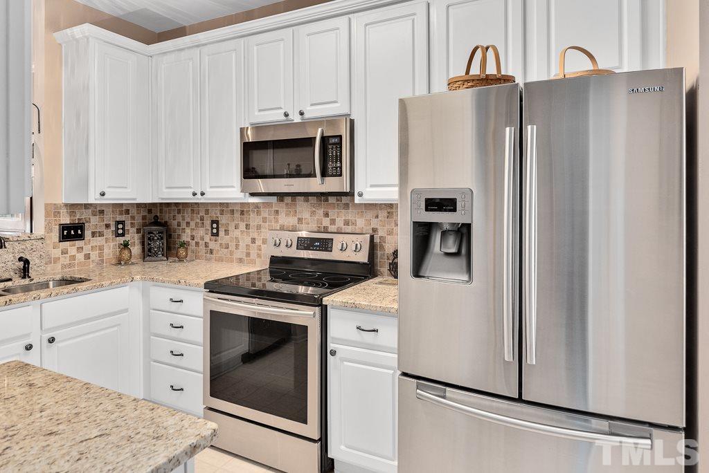 8348 City Loft Court Raleigh, NC 27613 - Photo 7 of 24 a kitchen with stainless steel appliances white cabinets white refrigerator and a stove