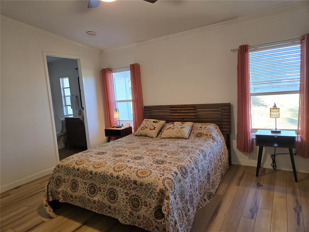 4146 Greenbluff Road, Unit 817 Zellwood, FL 32798 - Photo 29 of 40 a bedroom with a bed and wooden floor