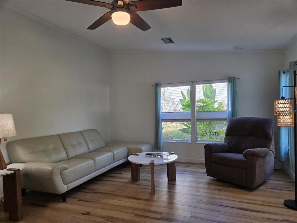4146 Greenbluff Road, Unit 817 Zellwood, FL 32798 - Photo 30 of 40 a living room with furniture and a large window
