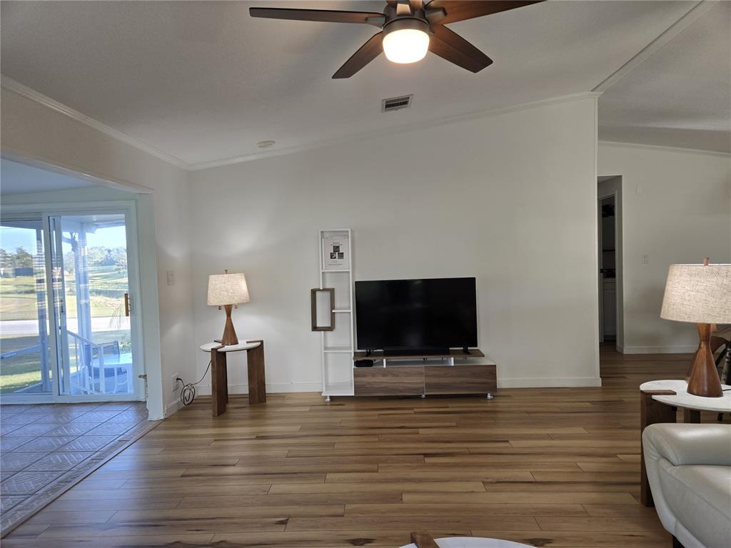 4146 Greenbluff Road, Unit 817 Zellwood, FL 32798 - Photo 32 of 40 a living room with furniture and a flat screen tv