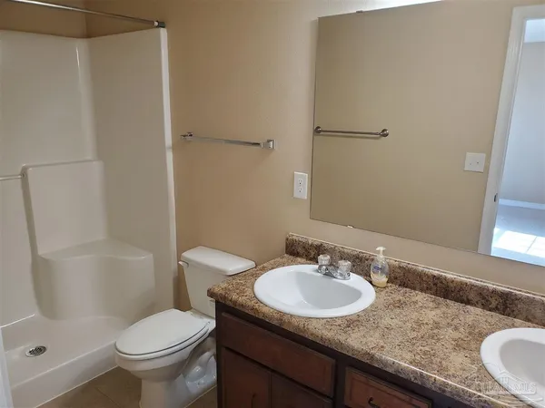 a bathroom with a granite countertop sink toilet and a mirror