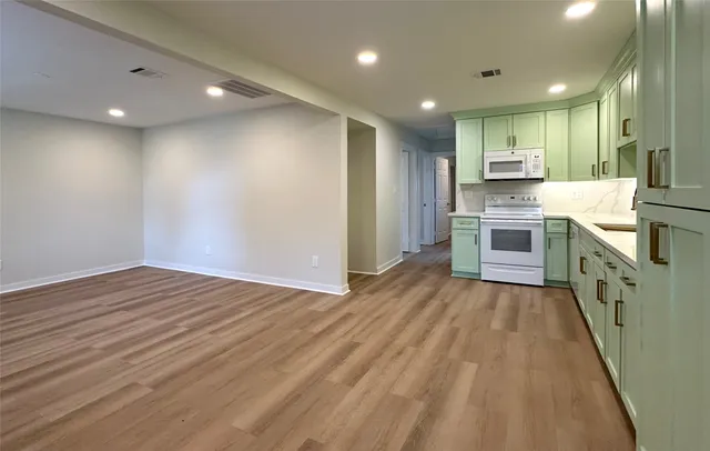 a kitchen with a sink cabinets and wooden floor