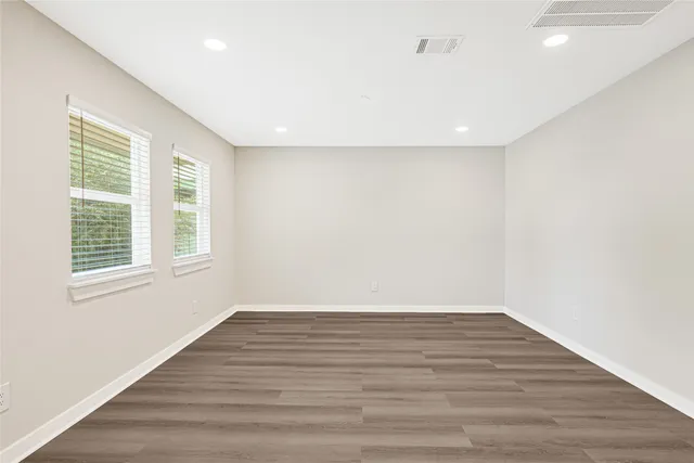 a view of an empty room with wooden floor