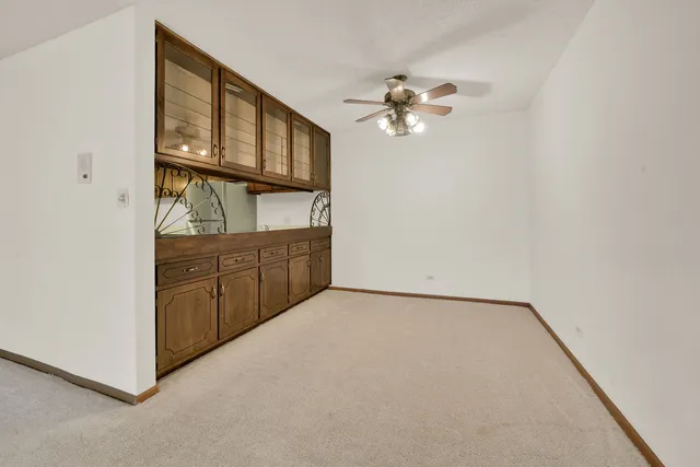 a view of an empty room with a chandelier fan