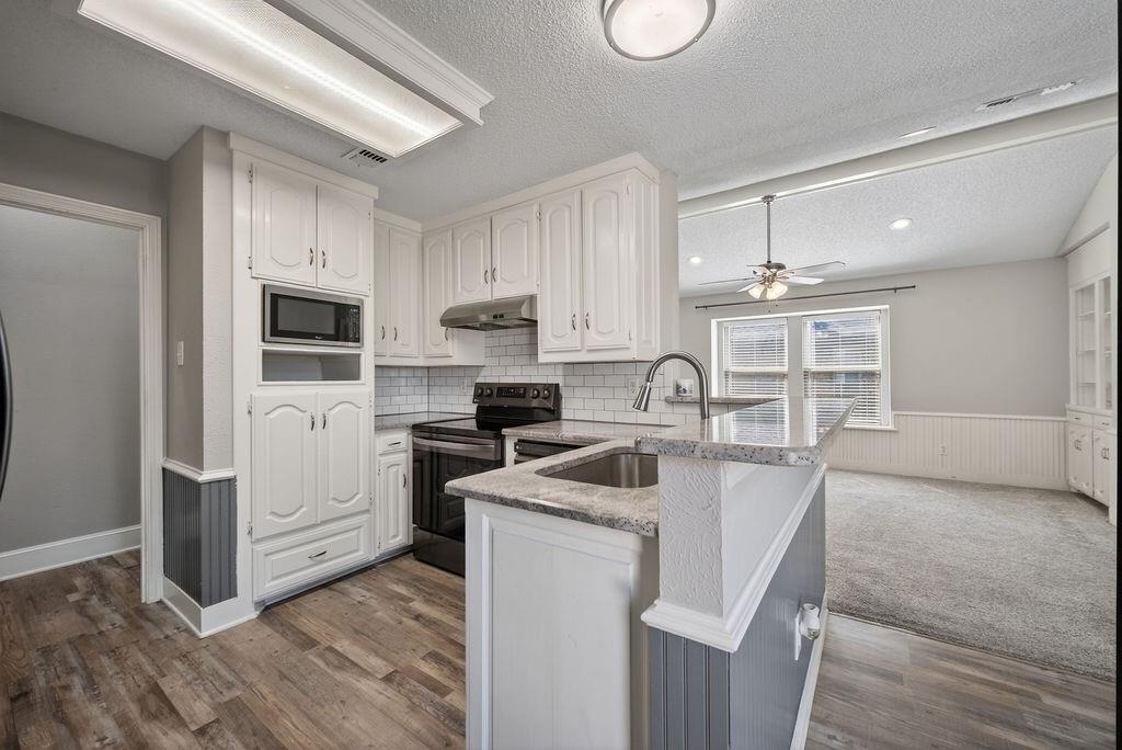 2229 Country Valley Road Garland, TX 75041 - Photo 17 of 34 a kitchen with stainless steel appliances granite countertop a sink a stove a refrigerator cabinets and a microwave