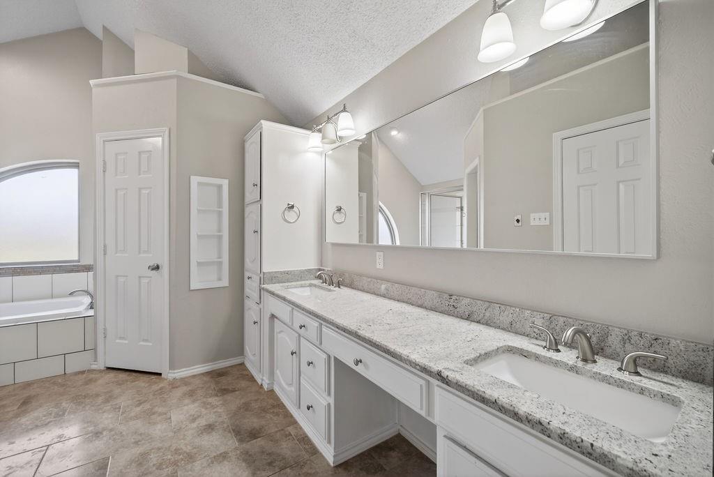 2229 Country Valley Road Garland, TX 75041 - Photo 23 of 34 a spacious bathroom with a granite countertop sink mirror and a