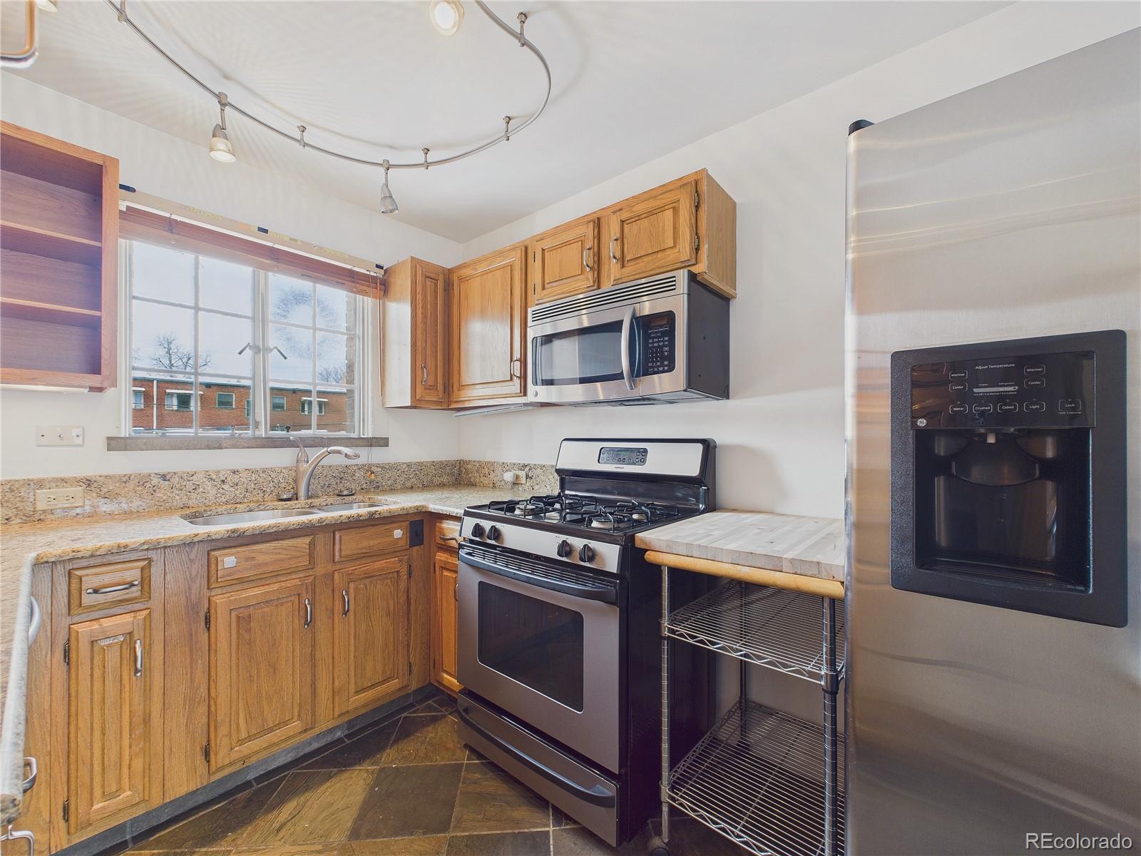 943 Emerson Street, Unit 4 Denver, CO 80218 - Photo 6 of 17 a kitchen with stainless steel appliances granite countertop a stove and a microwave