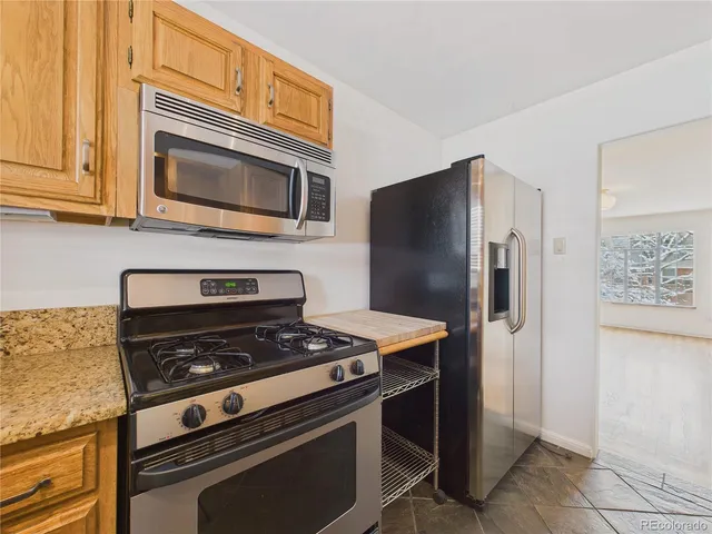 a kitchen with stainless steel appliances granite countertop a stove microwave and refrigerator