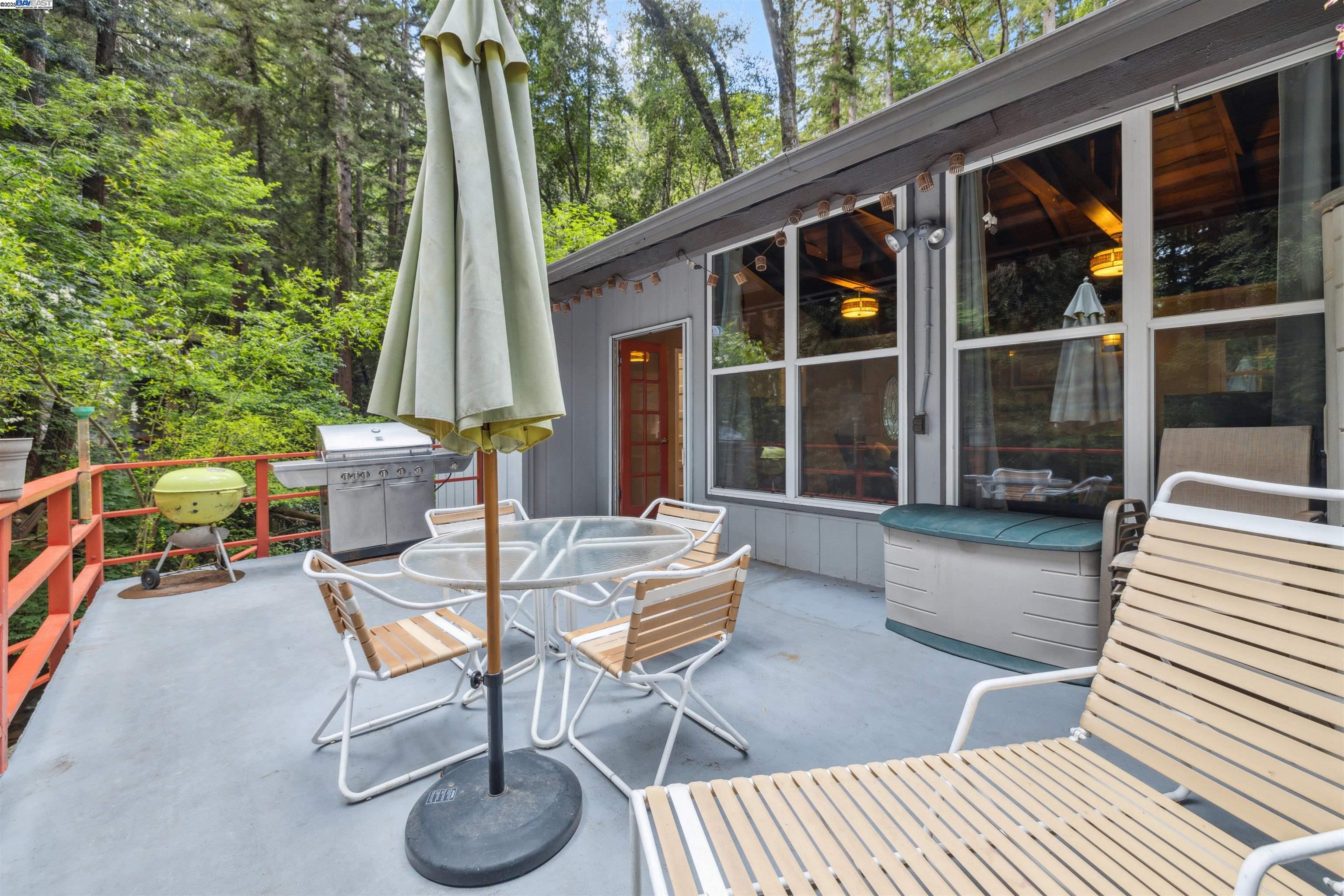 495 Primavera Road Boulder Creek, CA 95006 - Photo 16 of 33 a view of a patio with table and chairs and wooden floor