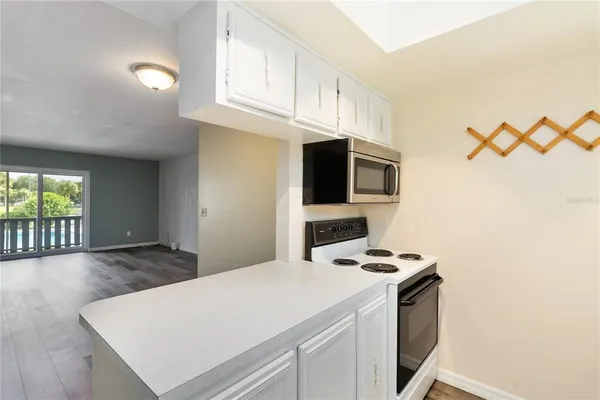a kitchen with stainless steel appliances a stove a microwave and white cabinets