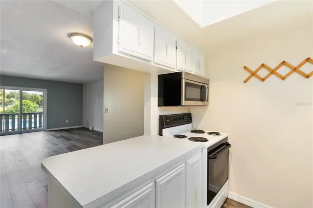a kitchen with stainless steel appliances a stove a microwave and white cabinets