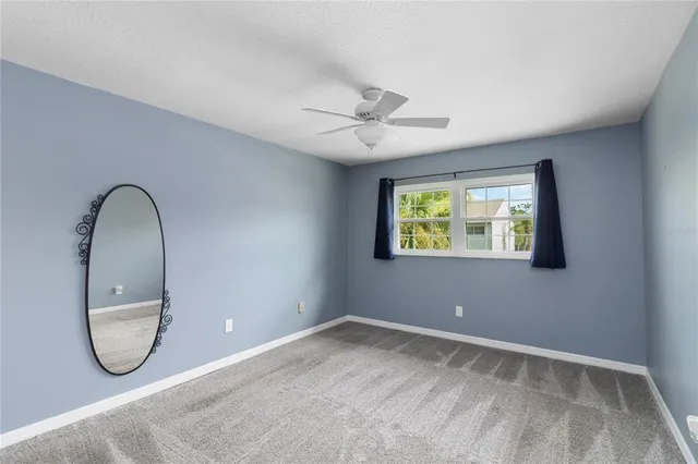 an empty room with windows and fan