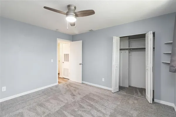 a view of an empty room and a ceiling fan