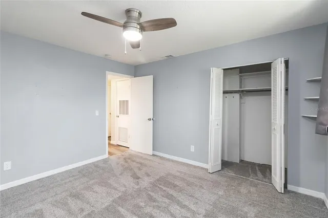 a view of an empty room and a ceiling fan