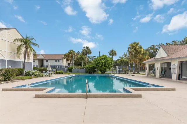 a view of pool with outdoor seating and city view