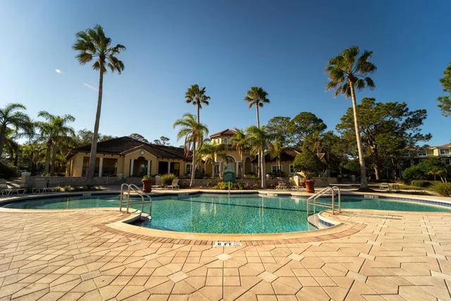 a view of a house with a yard and a palm tree