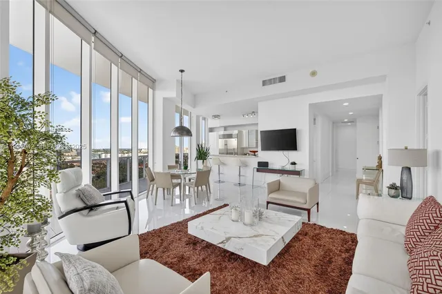 a living room with furniture a flat screen tv and a large window