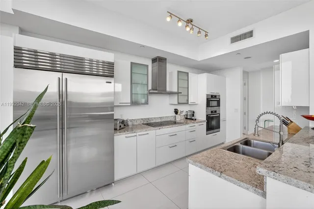 a kitchen with stainless steel appliances granite countertop a sink stove and refrigerator