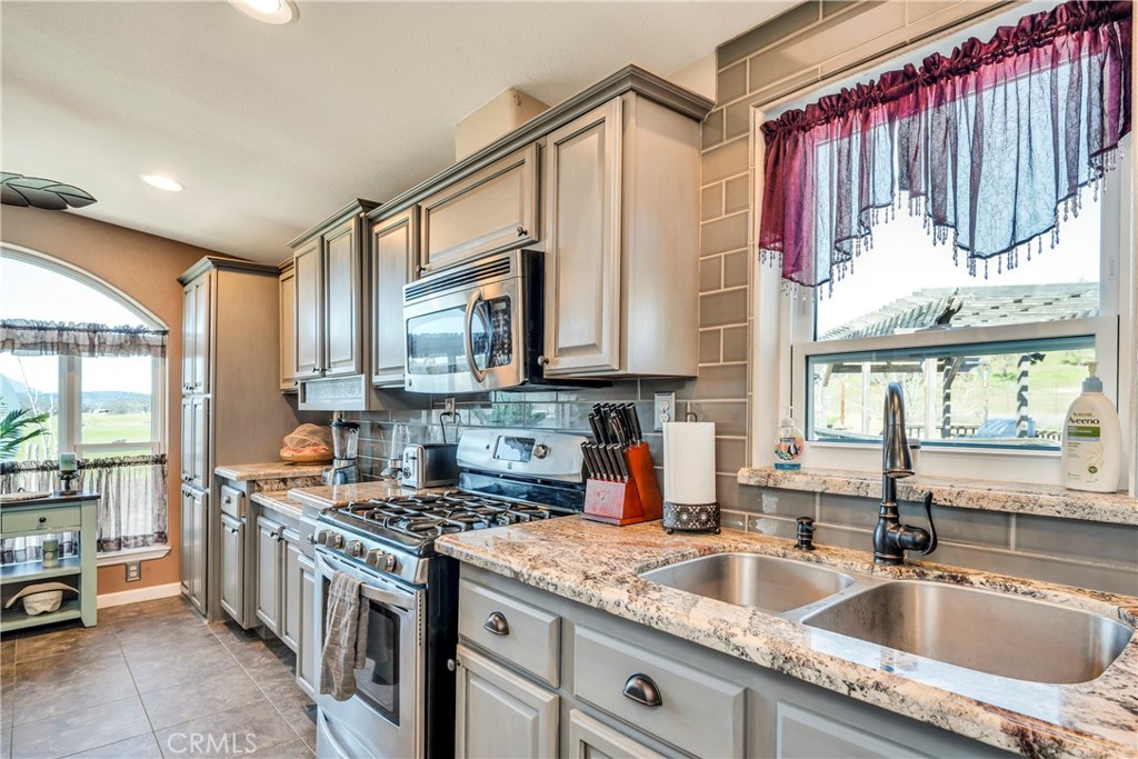 17432 Sendero Way Lower Lake, CA 95457 - Photo 32 of 65 a kitchen with stainless steel appliances granite countertop a sink a stove and a wooden floors