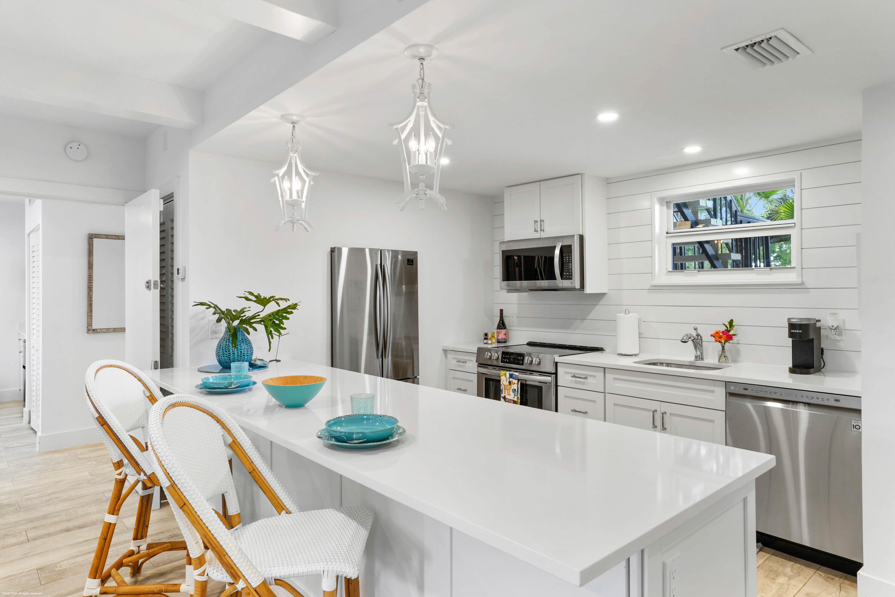 13334 Polo Club Road, Unit 234 Wellington, FL 33414 - Photo 2 of 41 a kitchen with stainless steel appliances granite countertop a dining table chairs and refrigerator