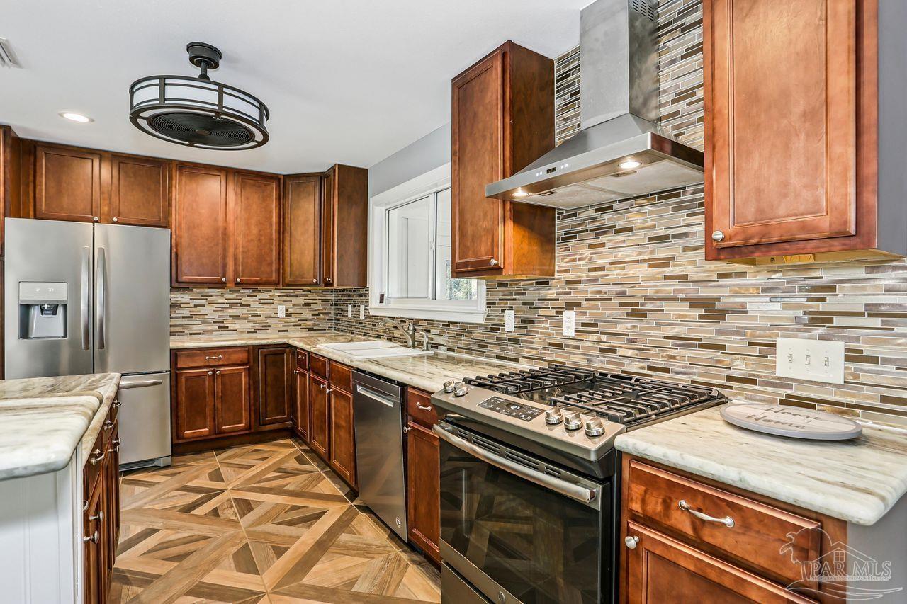 4900 Shell Road Milton, FL 32583 - Photo 13 of 52 a kitchen with stainless steel appliances granite countertop a stove a sink and a refrigerator