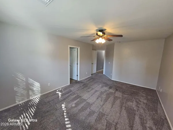 a view of a bedroom with a ceiling fan and a chandelier fan