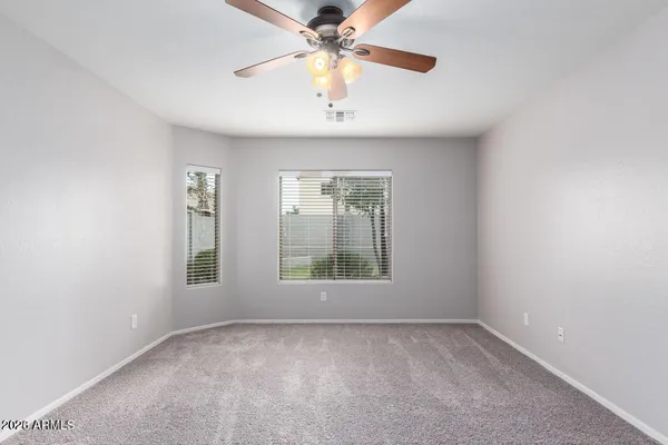 an empty room with a window and a fan