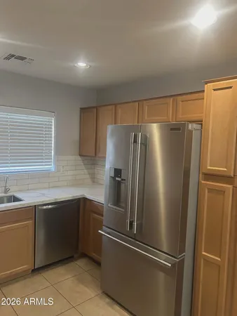 a metallic refrigerator freezer sitting inside of a kitchen