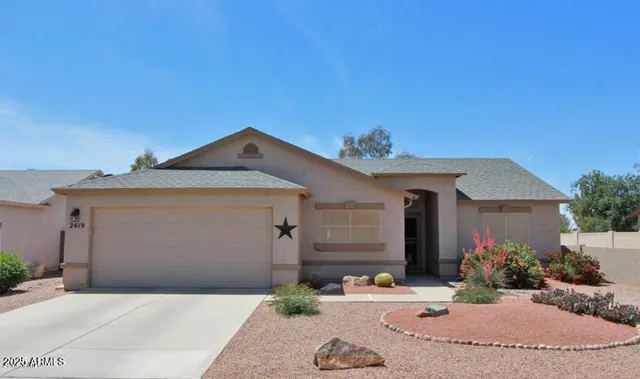 a view of a house with a yard and potted plants