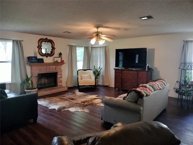 a living room with furniture a fireplace and a flat screen tv