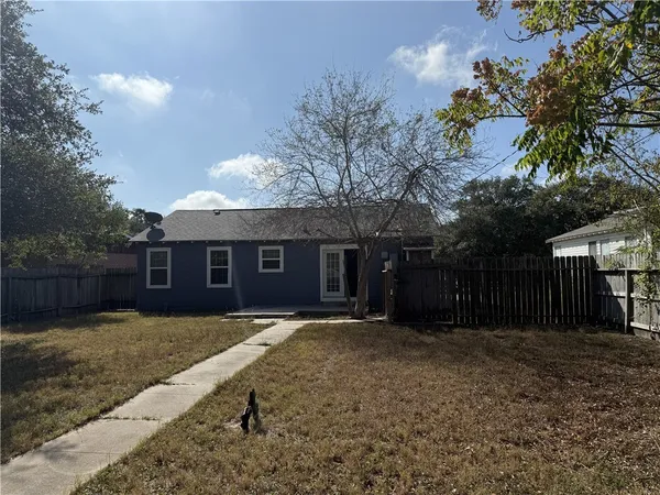 a front view of house with yard and trees