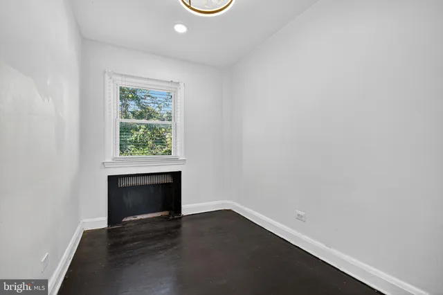an empty room with a fireplace and window