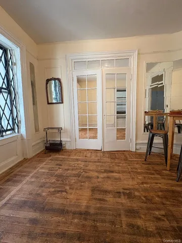 a view of an empty room with window and chair