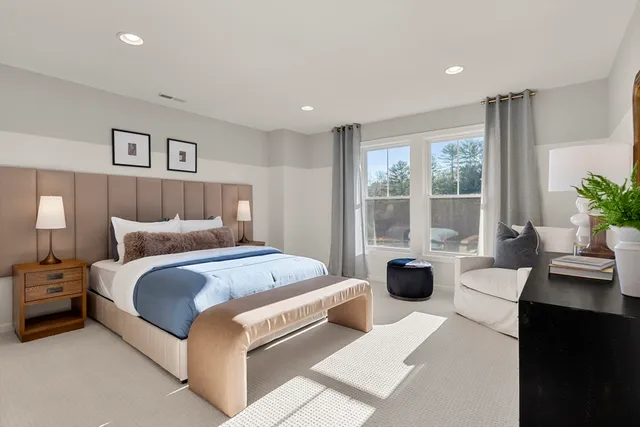 a spacious bedroom with a bed couch and windows