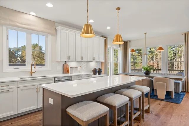 a kitchen with stainless steel appliances granite countertop a refrigerator a sink a stove and a wooden floors