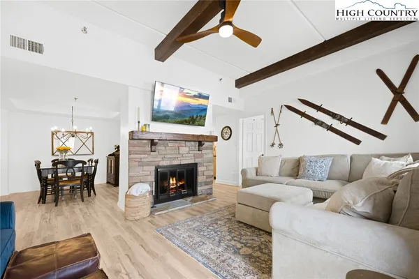 a living room with furniture a fireplace and a flat screen tv