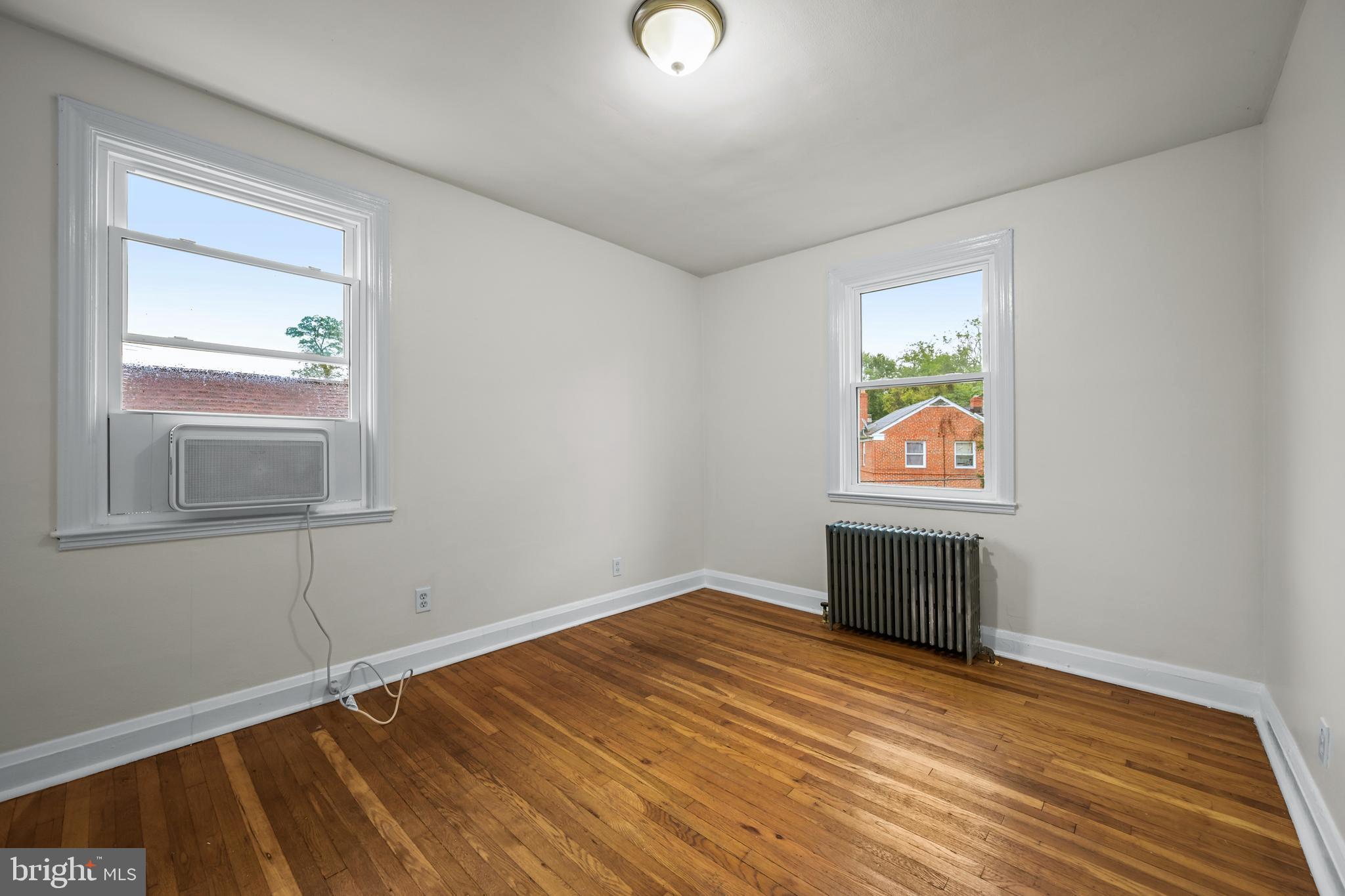 417 Random Road Baltimore, MD 21229 - Photo 18 of 32 a view of empty room with window and wooden floor