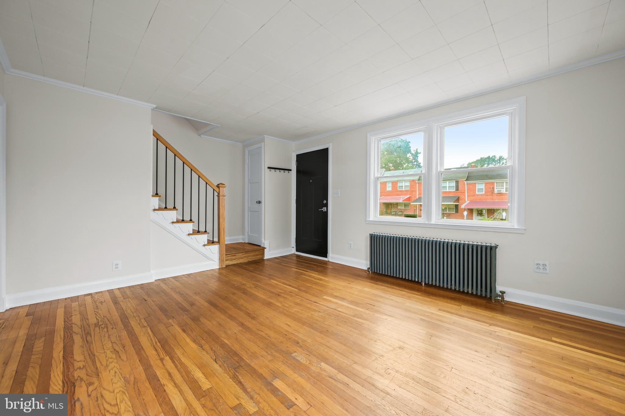 417 Random Road Baltimore, MD 21229 - Photo 7 of 32 a view of an empty room with wooden floor and a window