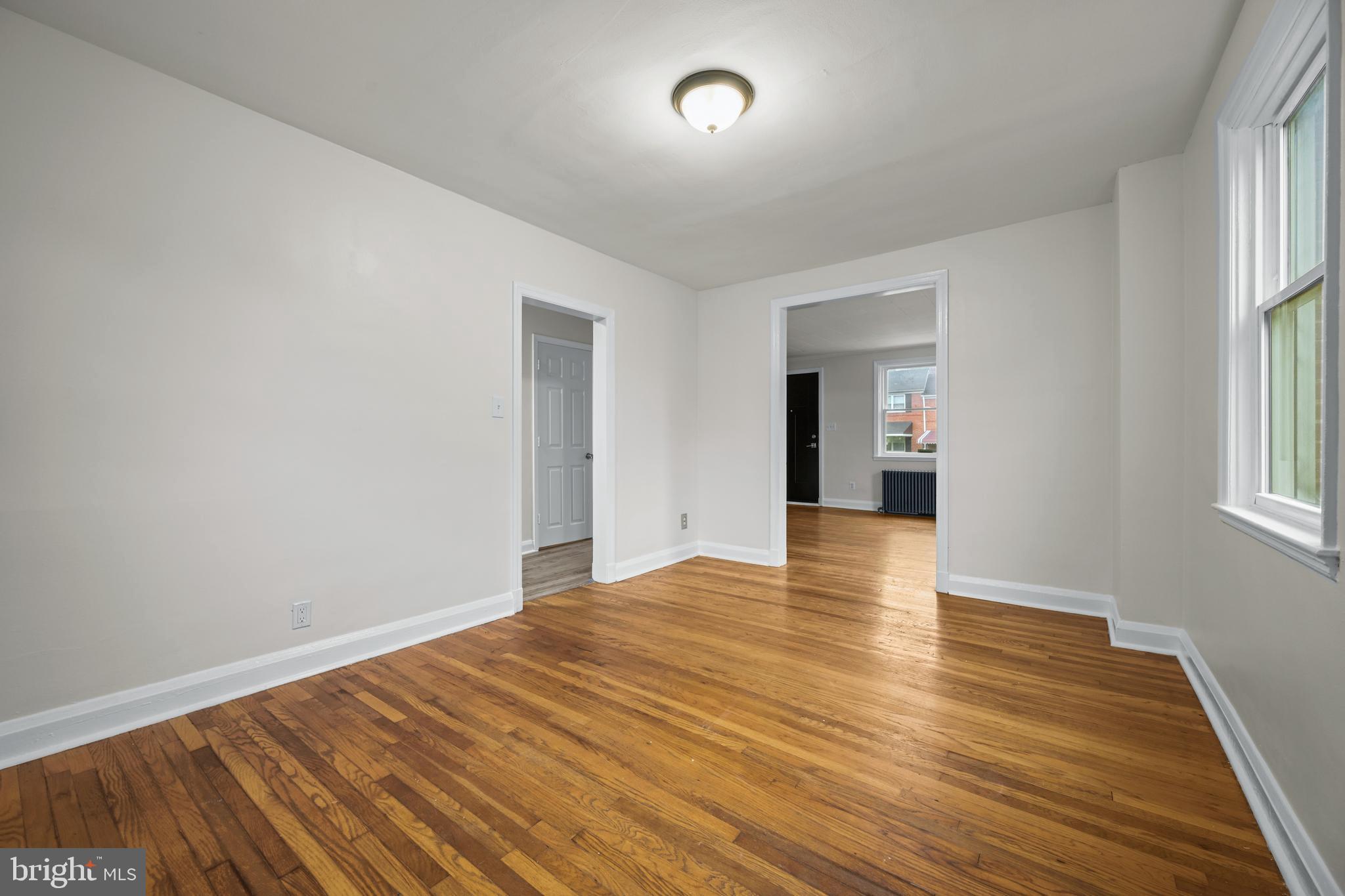 417 Random Road Baltimore, MD 21229 - Photo 10 of 32 a view of an empty room with wooden floor and a window