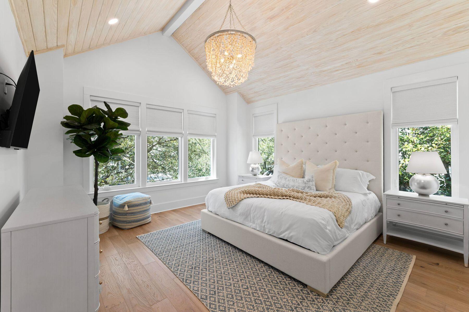 261 Defuniak Street Santa Rosa Beach, FL 32459 - Photo 14 of 27 a bedroom with a bed and a chandelier