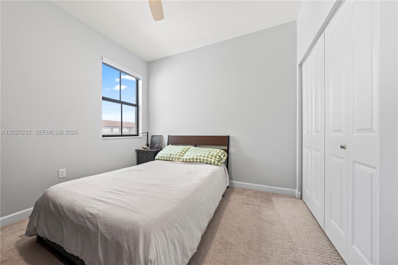 23489 Southwest 127th Place Homestead, FL 33032 - Photo 14 of 24 a bedroom with a bed and a window