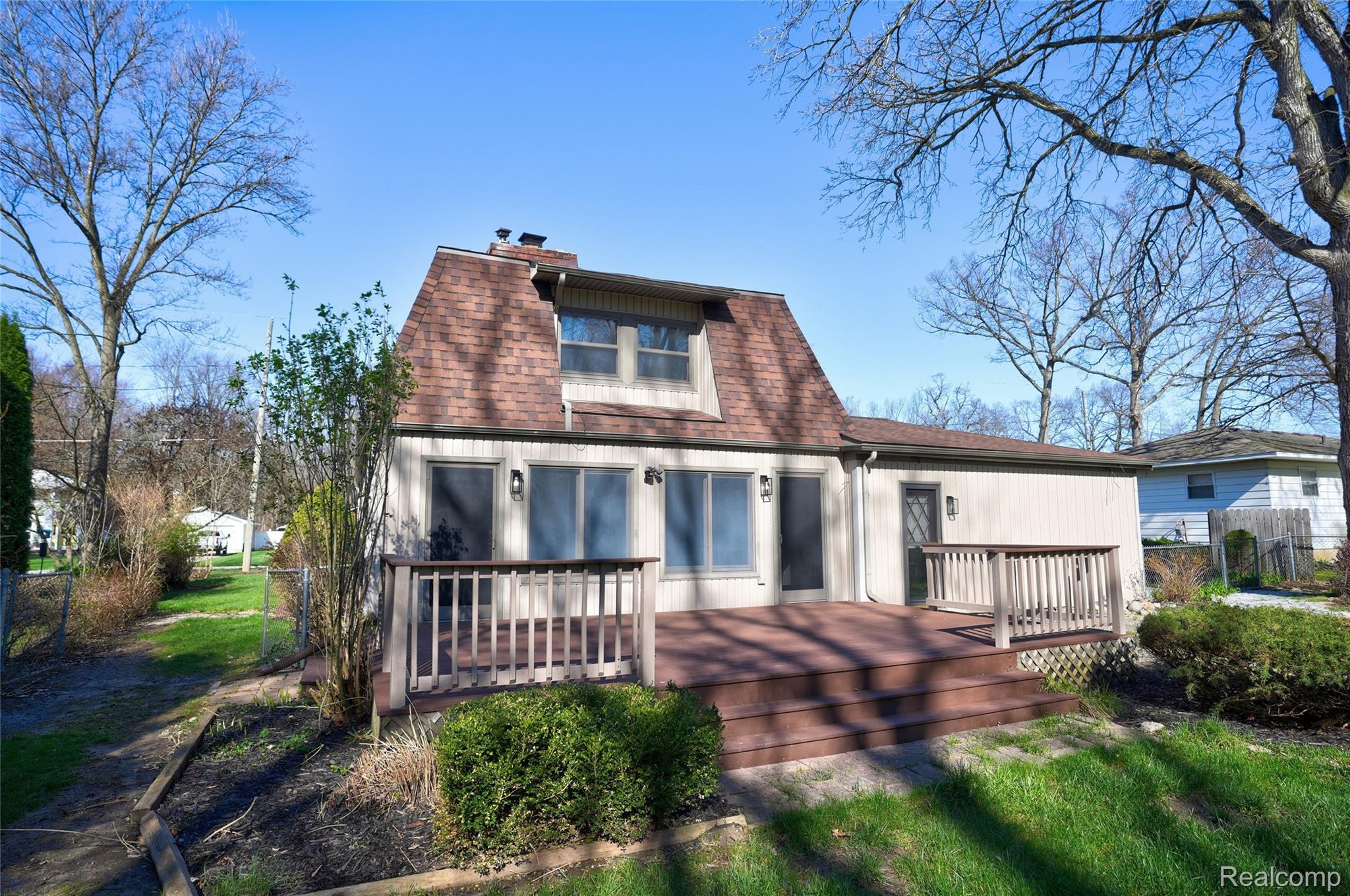 6273 Cold Spring Trail Grand Blanc, MI 48439 - Photo 6 of 48 Rear view of property featuring a shingled roof, a deck, and a chimney