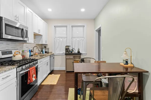 a kitchen with stainless steel appliances granite countertop a sink stove and microwave