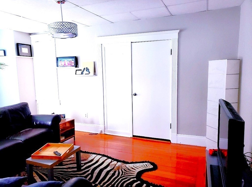 722 Adams Street, Unit 1 Boston, MA 02122 - Photo 2 of 10 a blue room with furniture and a flat screen tv