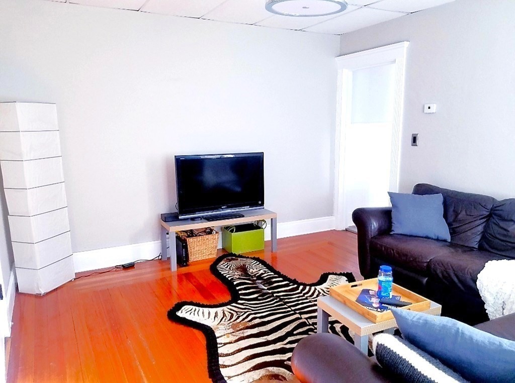 722 Adams Street, Unit 1 Boston, MA 02122 - Photo 3 of 10 a living room with furniture and a flat screen tv