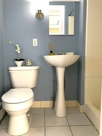 a bathroom with a toilet sink and mirror