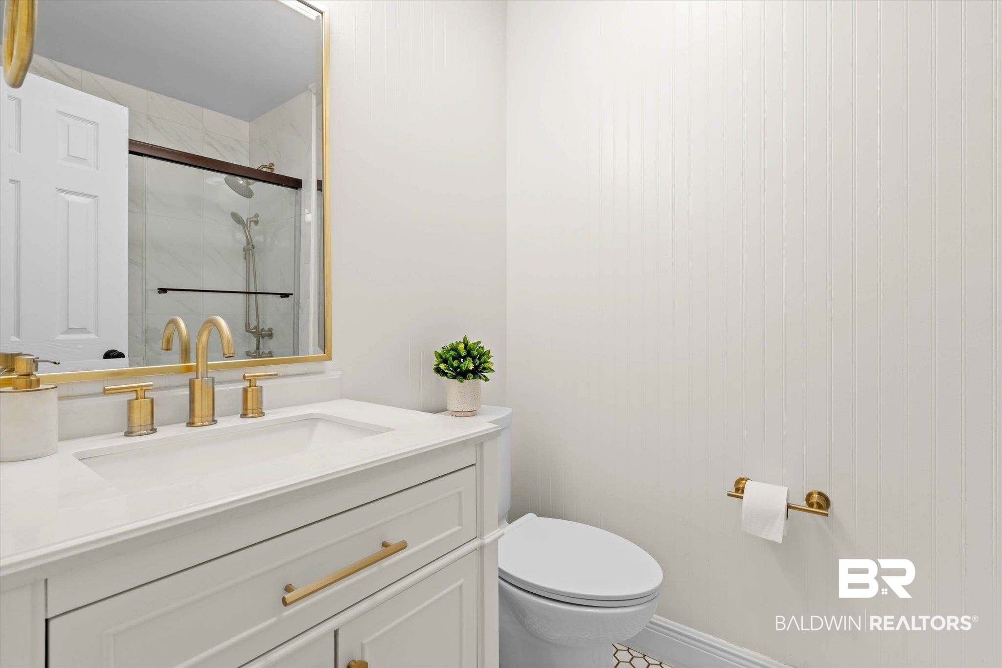 101 Ann Street Daphne, AL 36527 - Photo 19 of 38 Vanity featuring a white countertop, undermount sink, and brass-finish fixtures