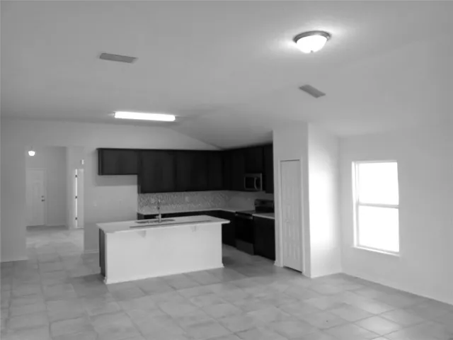 a kitchen with stainless steel appliances a refrigerator and a stove top oven